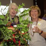 Margaret Gaines and Trish Mather hiding behind the festive decorations